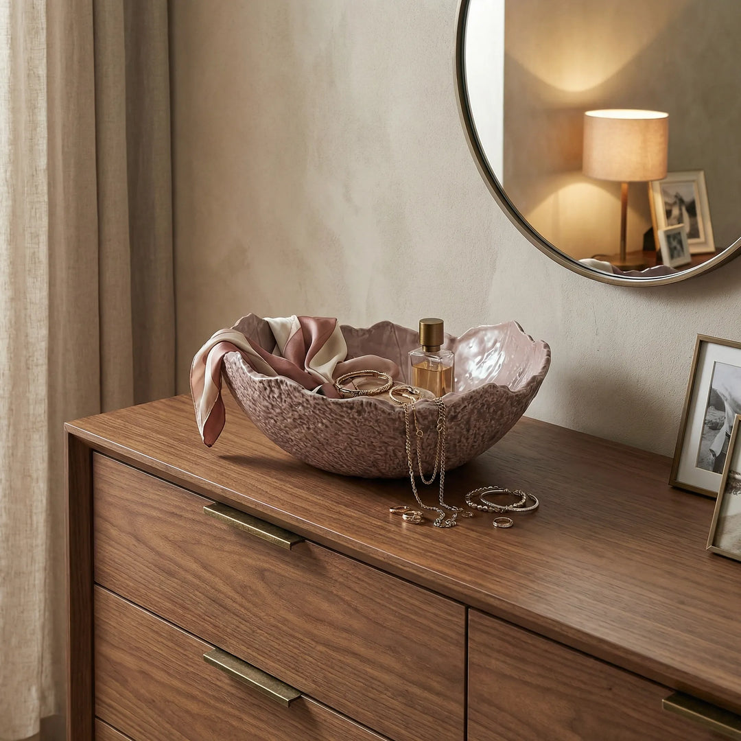 Ciotola decorativa in ceramica con gioielli e accessori su mobile in legno in ambiente elegante