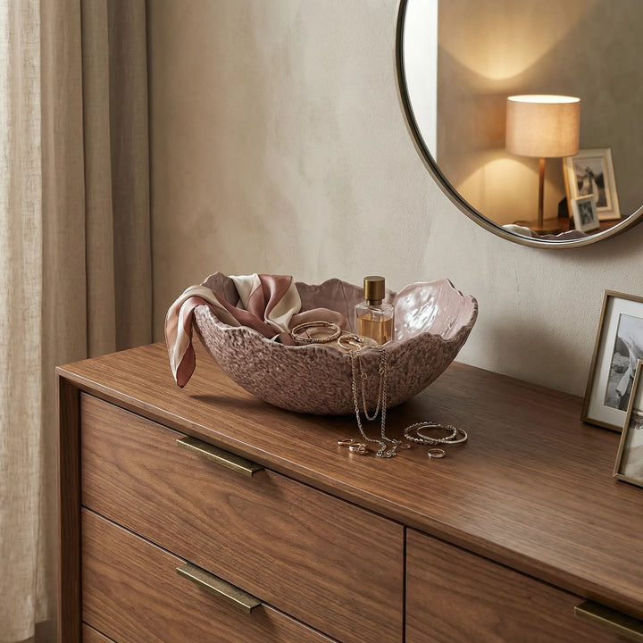 Ciotola decorativa in ceramica con gioielli e accessori su mobile in legno in ambiente elegante