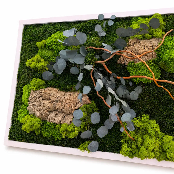 Dettaglio ravvicinato del quadro con muschio e licheni stabilizzati verdi, foglie di eucalipto, rami decorativi e corteccia naturale.