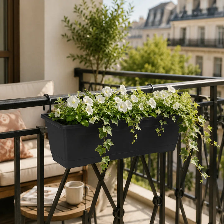 Kit Fioriera Birka nera installata su ringhiera da balcone con petunie bianche e edera ricadente, ideale per arredare spazi esterni con eleganza e praticità.