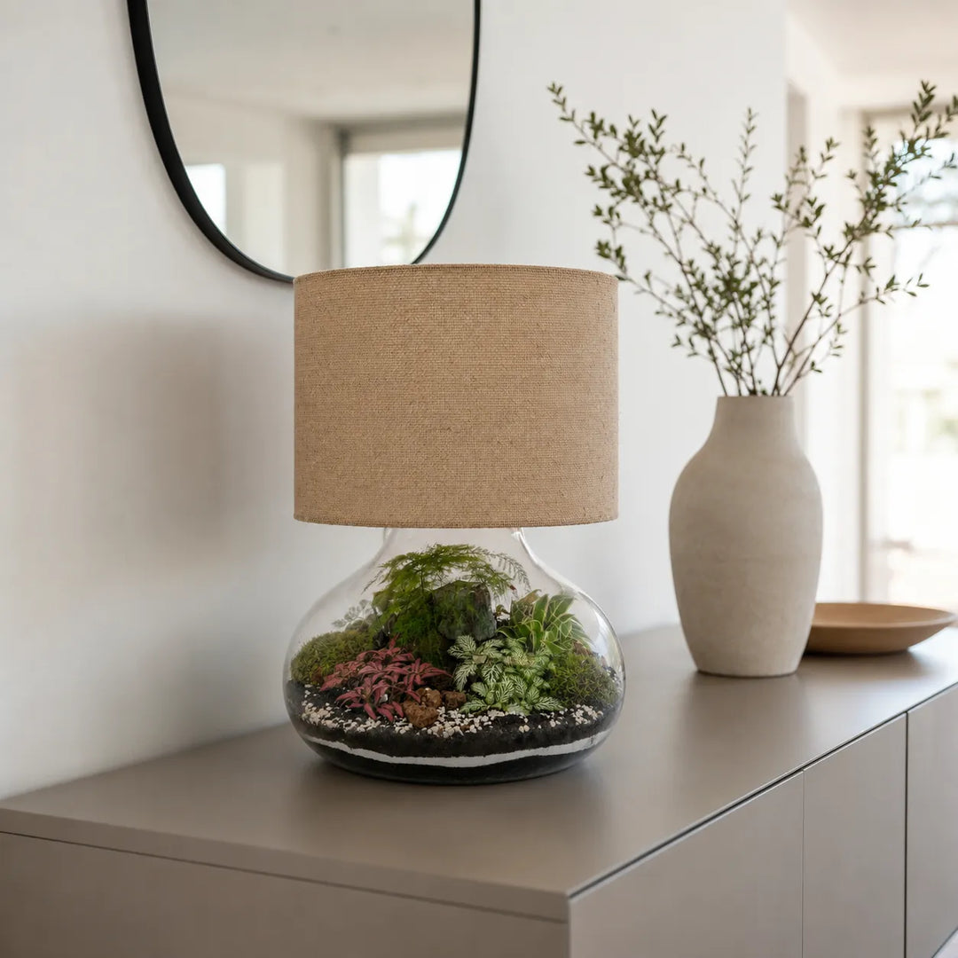 Lampada terrarium Lamparium Flora XXL con paralume in juta su una credenza moderna, complemento d'arredo elegante per soggiorno o ingresso.