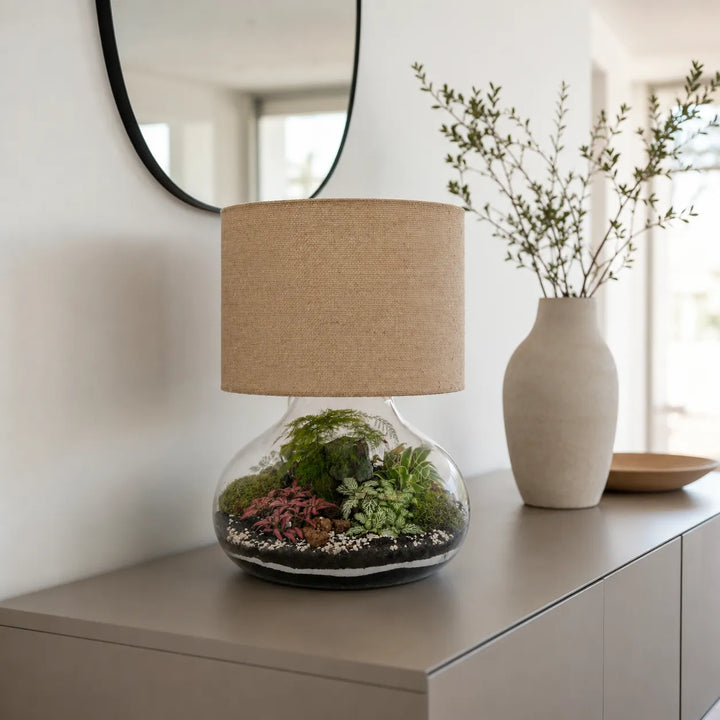 Lampada terrarium Lamparium Flora XXL con paralume in juta su una credenza moderna, complemento d'arredo elegante per soggiorno o ingresso.