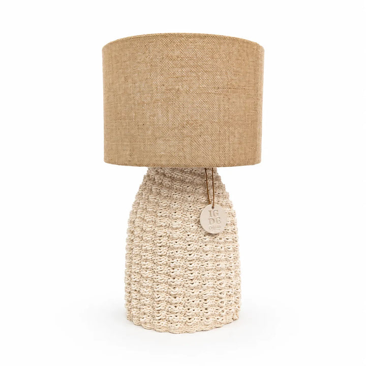 Lampada artigianale Fira accesa su comodino in legno con illuminazione soffusa e atmosfera accogliente in camera da letto.