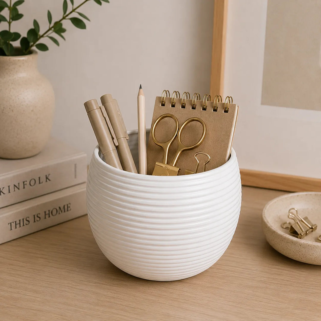 Vaso Sally bianco in ceramica impiegato come organizer da scrivania con quaderno, penne, forbici e fermagli, perfetto per arredare uffici e studi moderni.