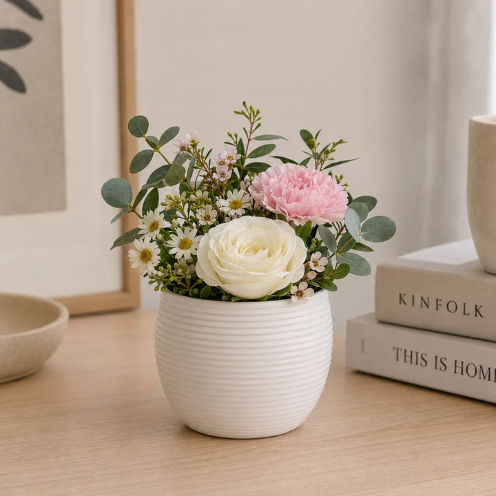 Vaso Sally bianco in ceramica con composizione floreale di rosa bianca, garofano rosa, margherite ed eucalipto, ideale come decorazione elegante per la casa.