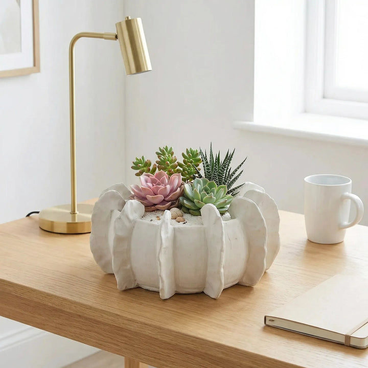 Vaso in ceramica artigianale con succulente su scrivania minimal con lampada e taccuino