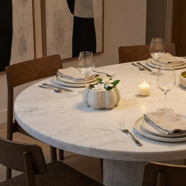 Vaso decorativo in ceramica con fiori su tavolo da pranzo elegante con piatti e bicchieri