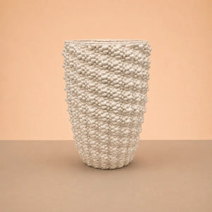 Vaso Santorini in argilla artigianale bianca con finitura lucida, forma alta e superficie decorativa materica in rilievo.