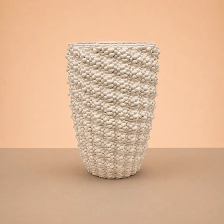 Vaso Santorini in argilla artigianale bianca con finitura lucida, forma alta e superficie decorativa materica in rilievo.