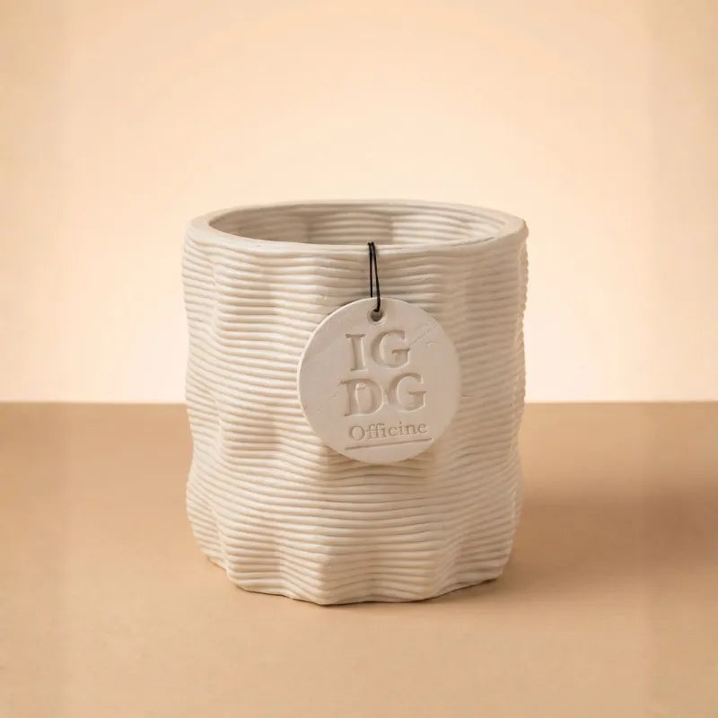 Vaso in ceramica beige con texture ondulata su sfondo neutro minimal