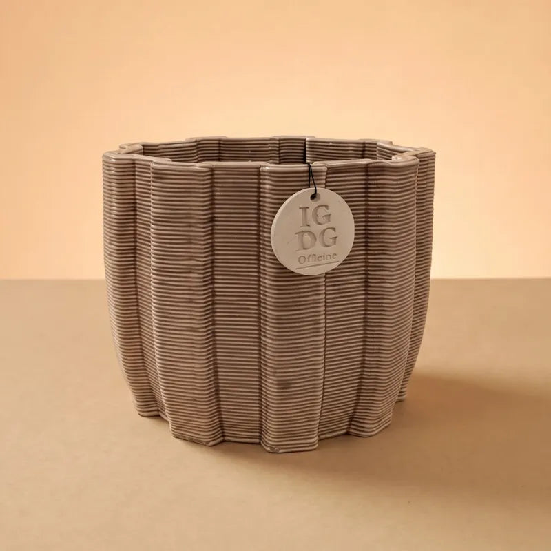 Vaso artigianale ovale beige con texture rigata su sfondo neutro minimal