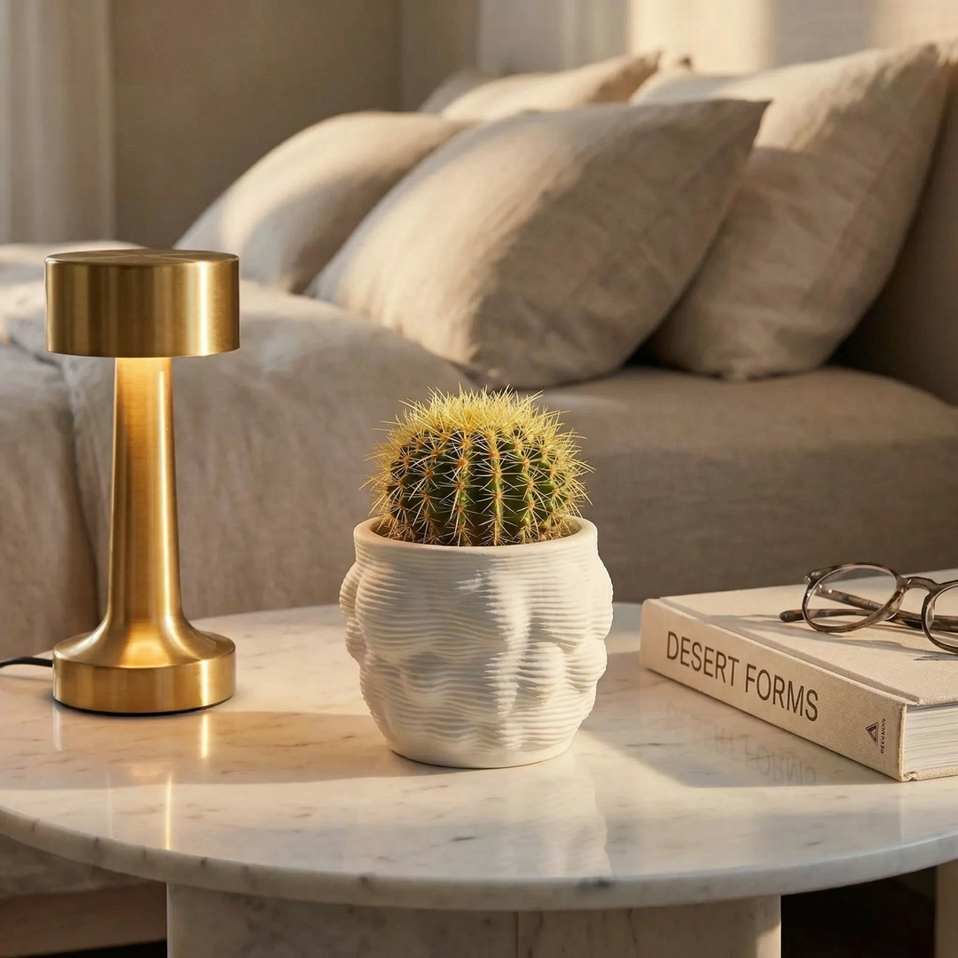 Vaso artigianale Alba in ceramica con cactus su tavolino accanto a lampada e libro