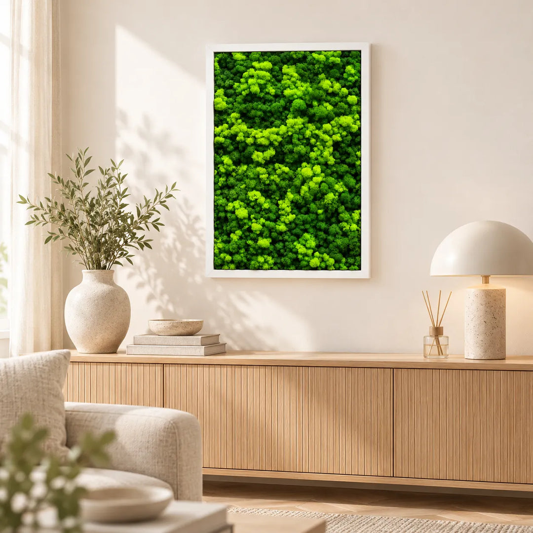 Quadro di lichene stabilizzato 63x45 cm con cornice bianca appeso sopra la credenza in legno del soggiorno