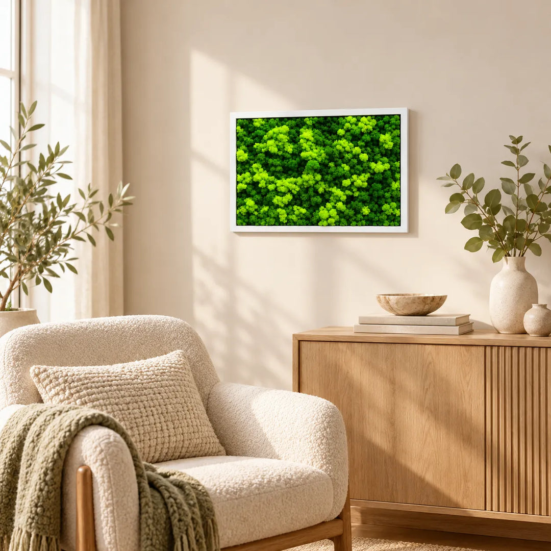 Quadro di licheni stabilizzati con cornice bianca sopra un mobile in legno in salotto con poltrona, interior design verde